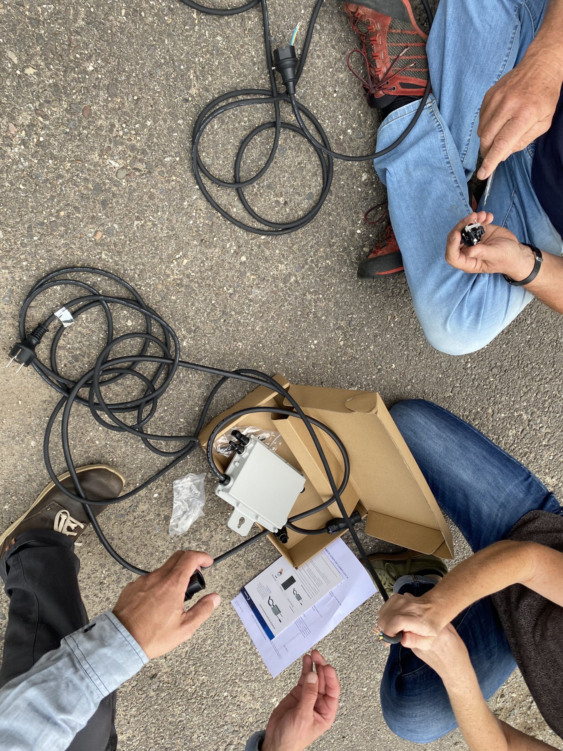 Menschen haben Kabel einer Photovoltaik Anlage für Balkone in der Hand. 